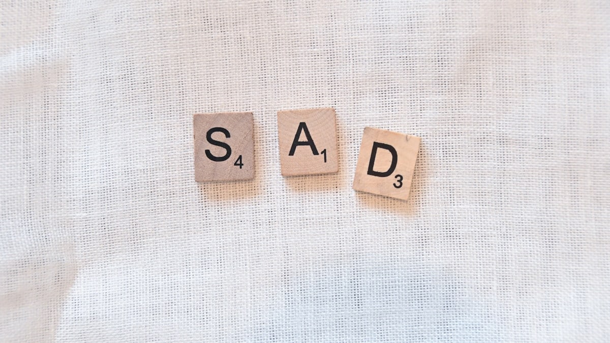scrabble pieces spelling out sad
